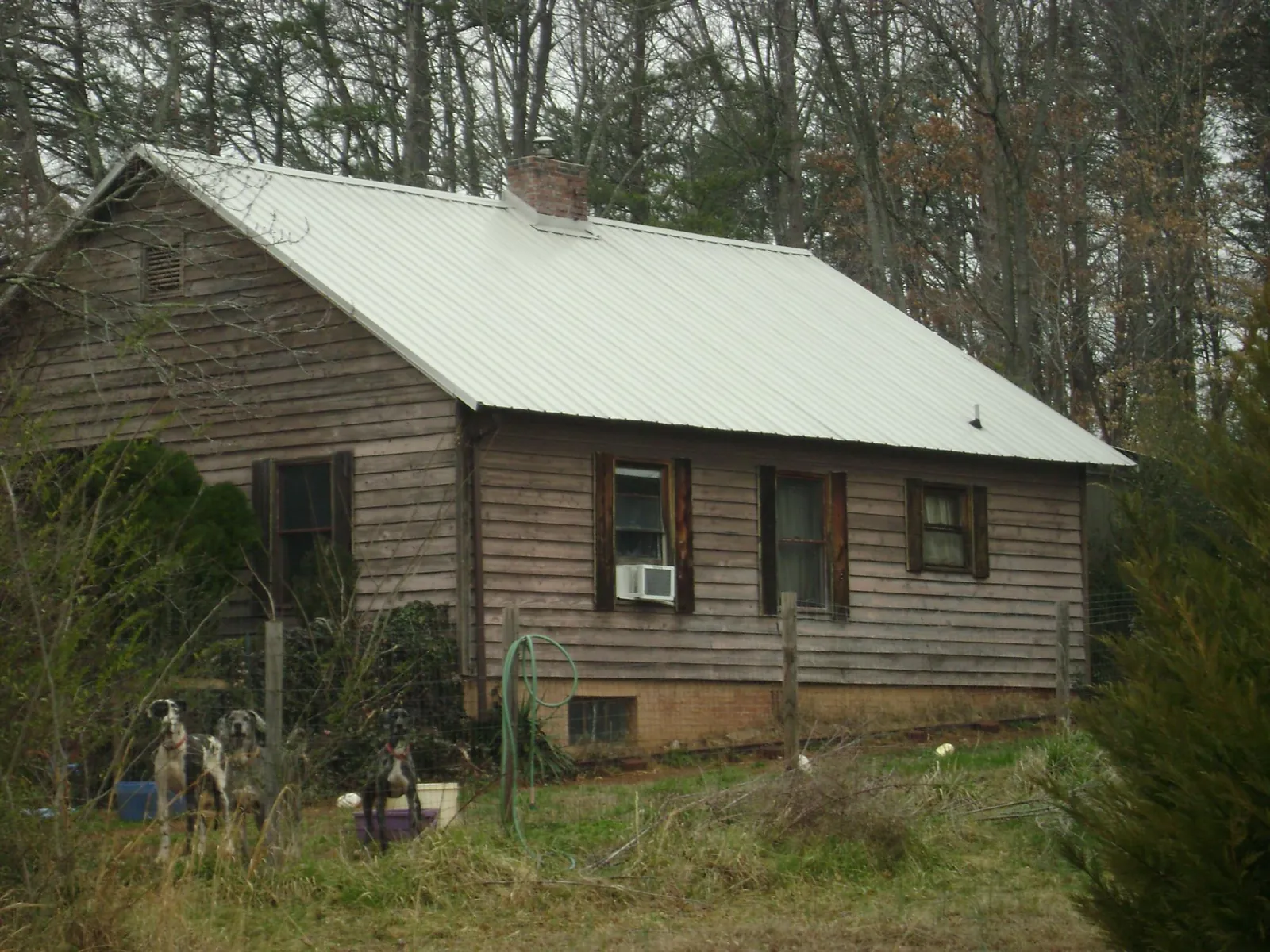 White metal roof on an old wood sided farmhouse, from a Metal Roof Installation job in Conner